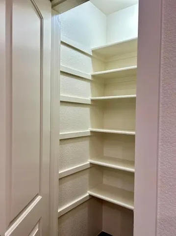 a view of walk in closet with empty racks