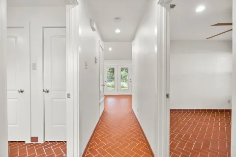 a view of a hallway with wooden floor and entryway