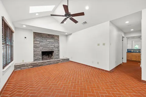 a view of an empty room with a fireplace and a window