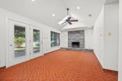 a view of an empty room with window and fire place