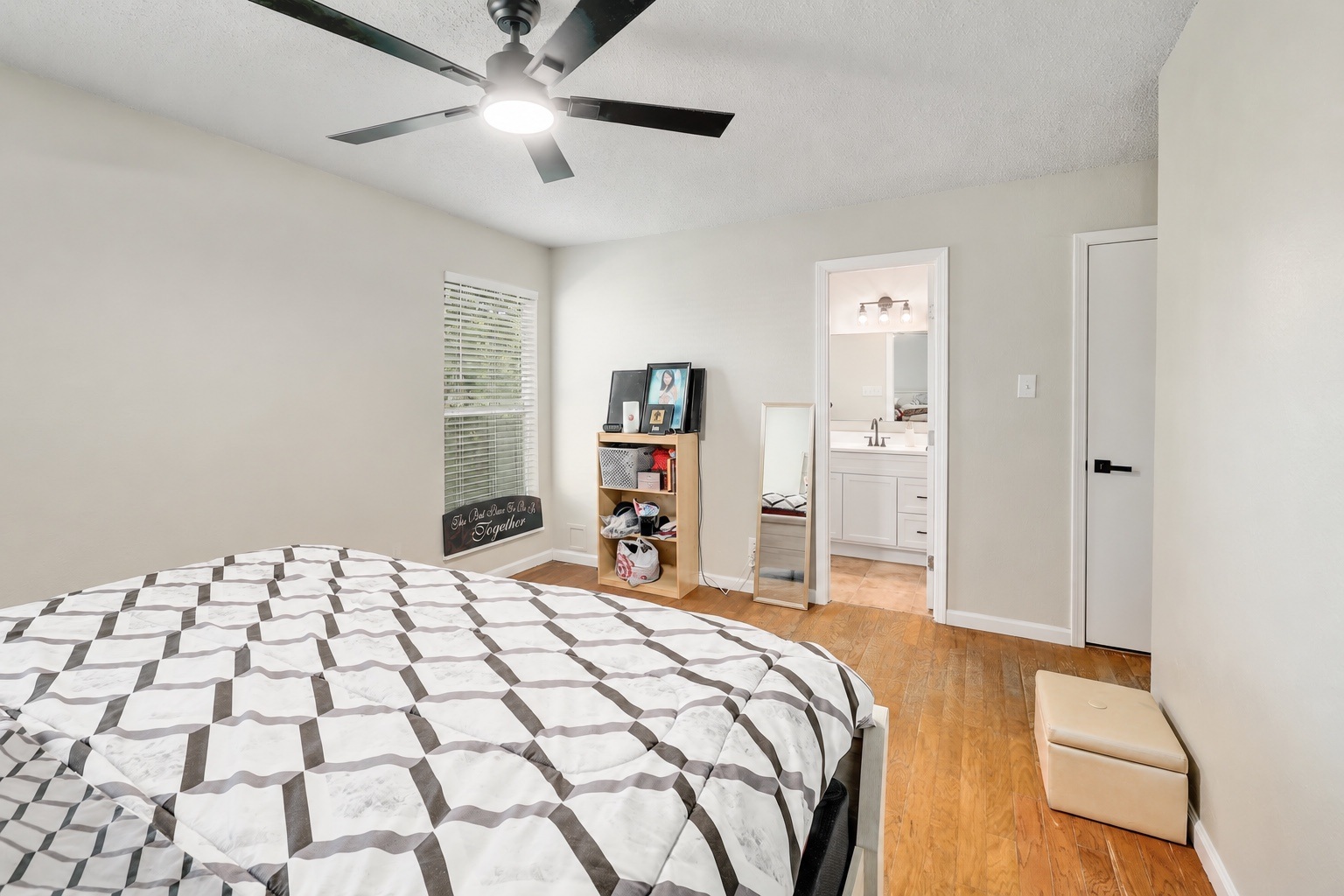 9906 Parliament House Road Austin, TX 78729 - Photo 12 of 33 Warm hardwood flooring flows throughout this bedroom featuring an attached private bathroom.