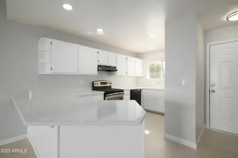 a kitchen with a sink a stove a refrigerator cabinets and a window