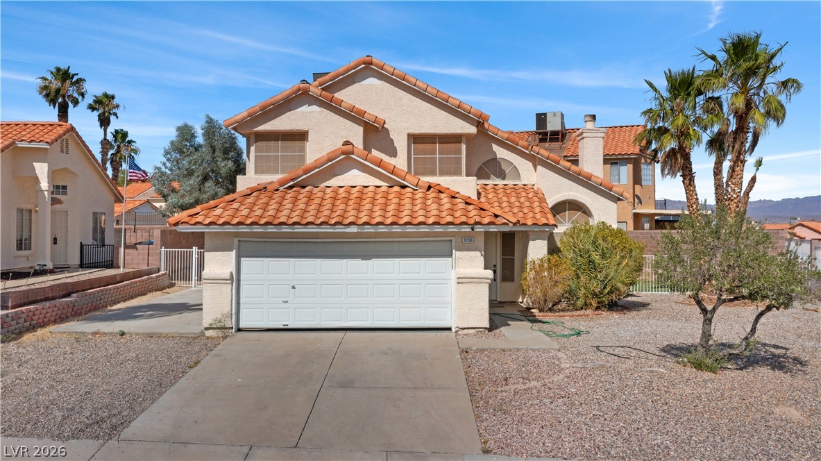 3156 Terrace View Drive Laughlin, NV 89029 - Photo 70 of 94 Discover desert living with this two-story stucco home, featuring a prominent garage and a xeriscaped front yard.