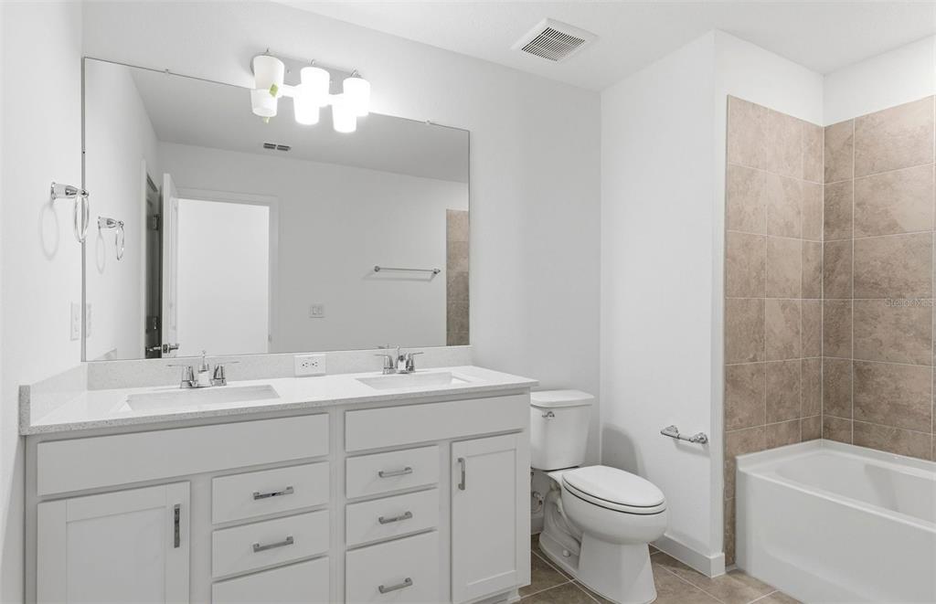 36877 Rio Grande Drive Zephyrhills, FL 33540 - Photo 14 of 26 a bathroom with a toilet a sink a tub and mirror