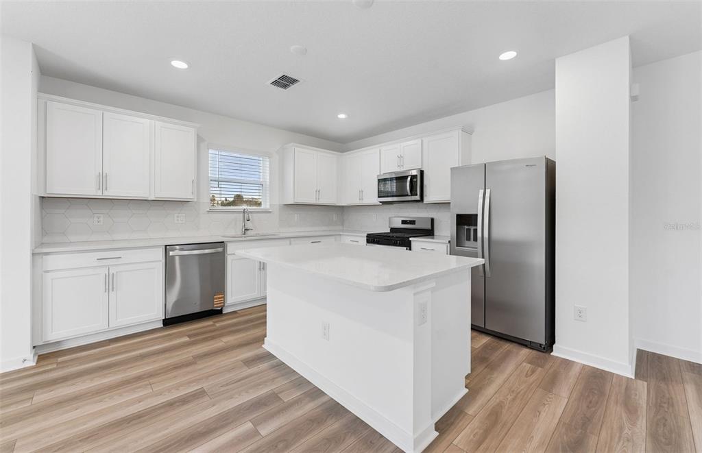 36877 Rio Grande Drive Zephyrhills, FL 33540 - Photo 3 of 26 a kitchen with a refrigerator a sink and dishwasher with wooden floor