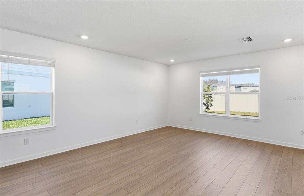 36877 Rio Grande Drive Zephyrhills, FL 33540 - Photo 5 of 26 an empty room with wooden floor and windows