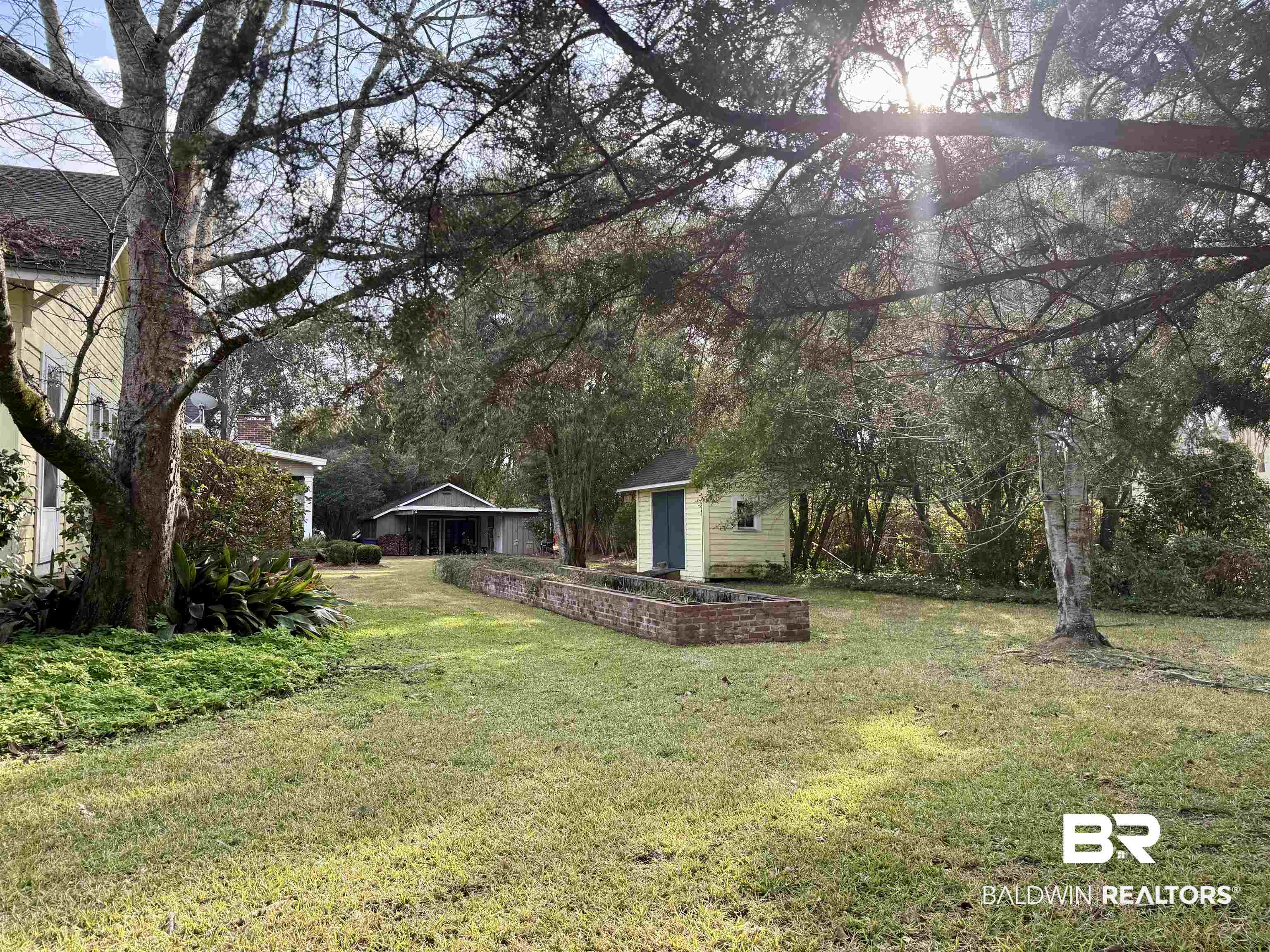 423 Evergreen Avenue Brewton, AL 36426 - Photo 18 of 18 View of green lawn with an outdoor structure and view of wooded area
