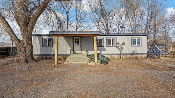 a view of a house with a yard and large tree