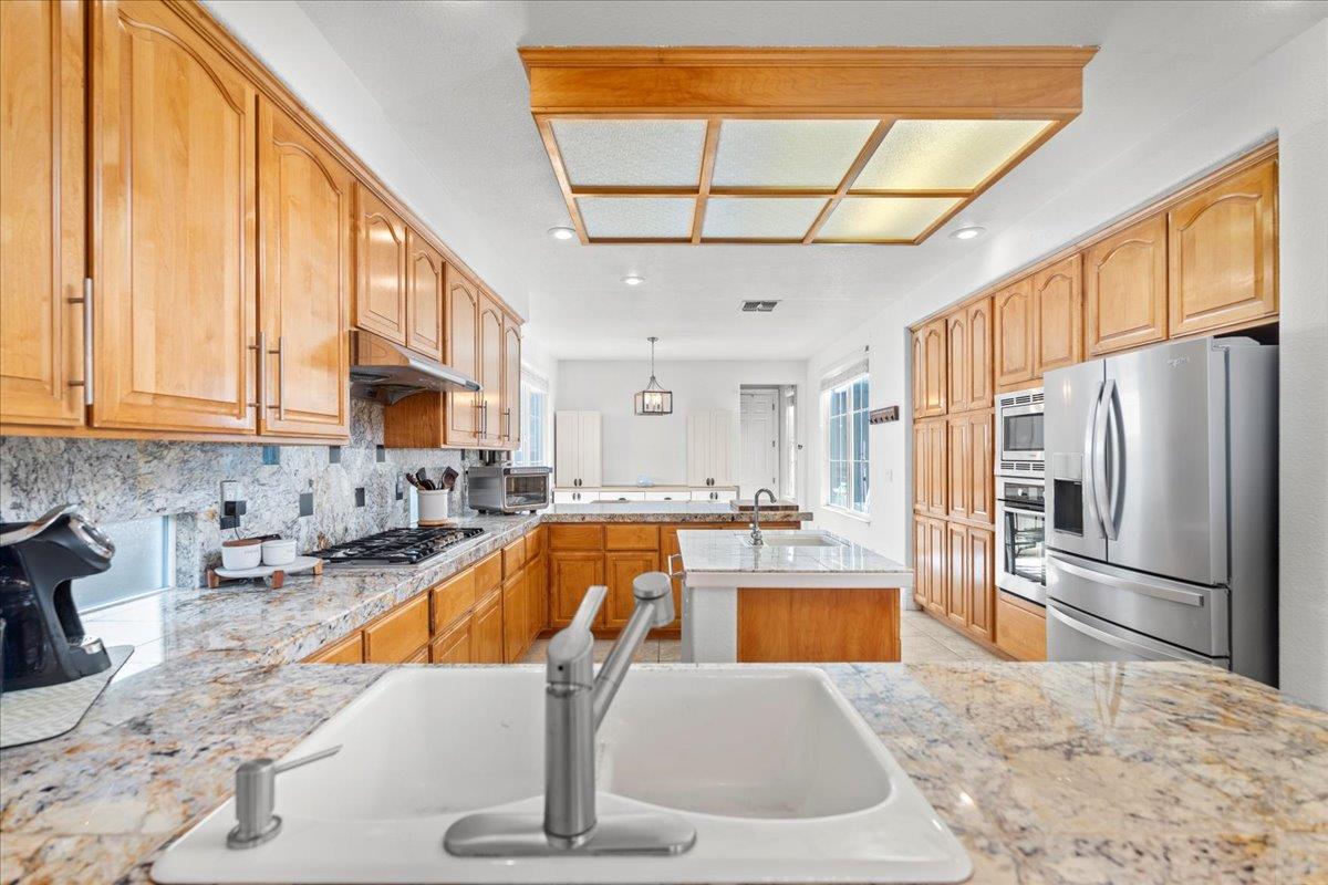 9168 Sipler Way Elk Grove, CA 95758 - Photo 14 of 35 a kitchen with stainless steel appliances granite countertop a refrigerator a stove and a sink with cabinets