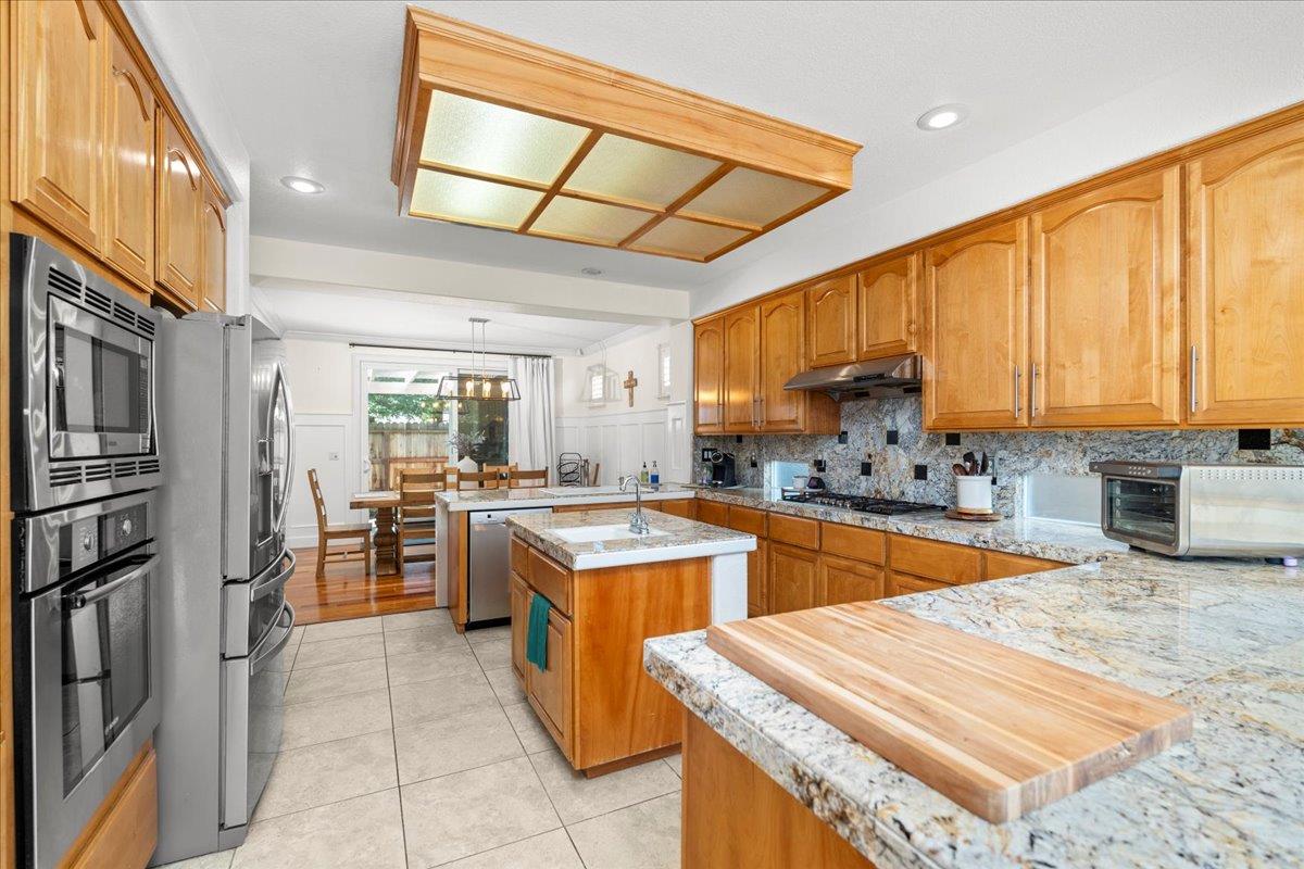 9168 Sipler Way Elk Grove, CA 95758 - Photo 15 of 35 a kitchen with stainless steel appliances granite countertop sink stove refrigerator and cabinets