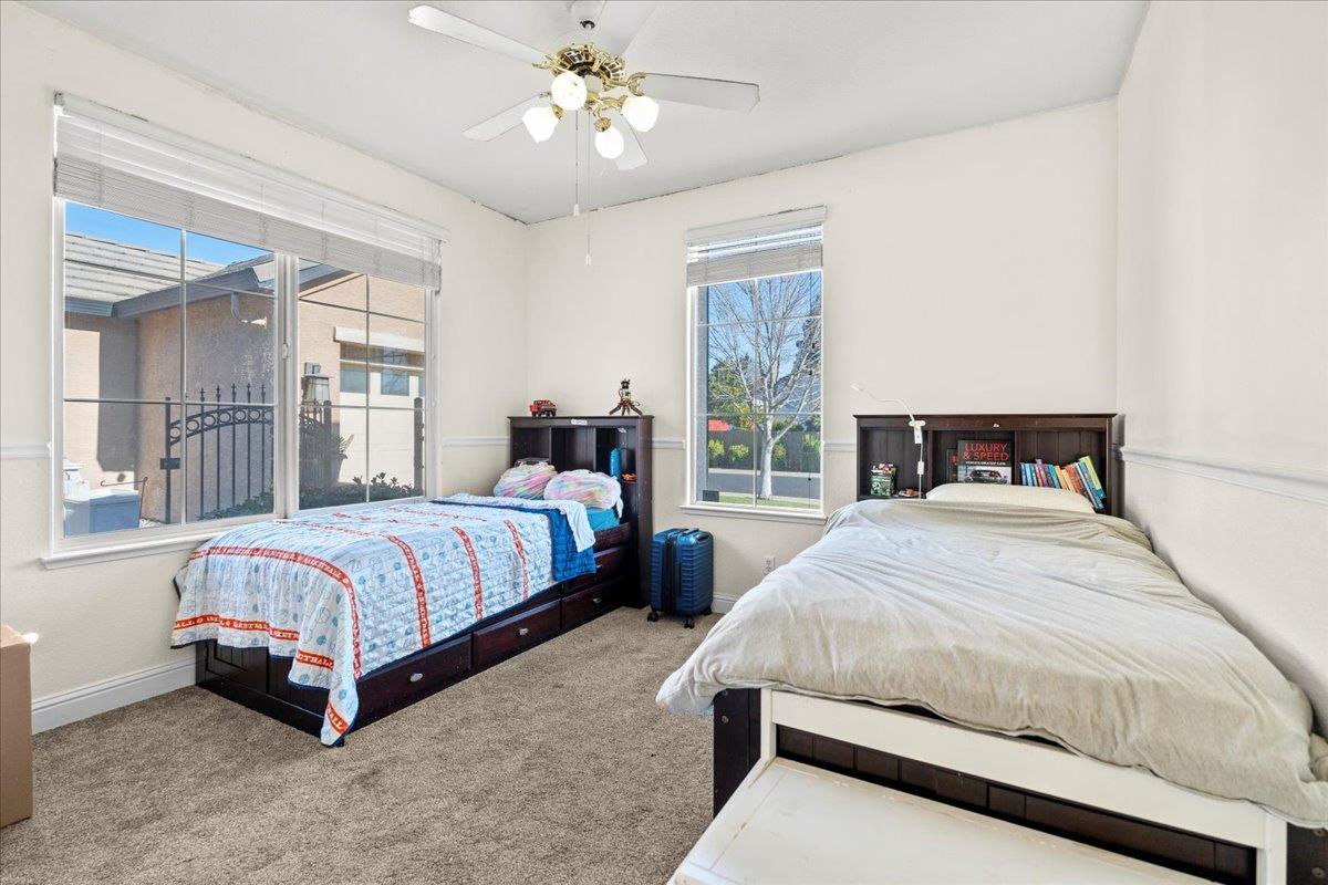 9168 Sipler Way Elk Grove, CA 95758 - Photo 25 of 35 a bedroom with a large bed and a chandelier