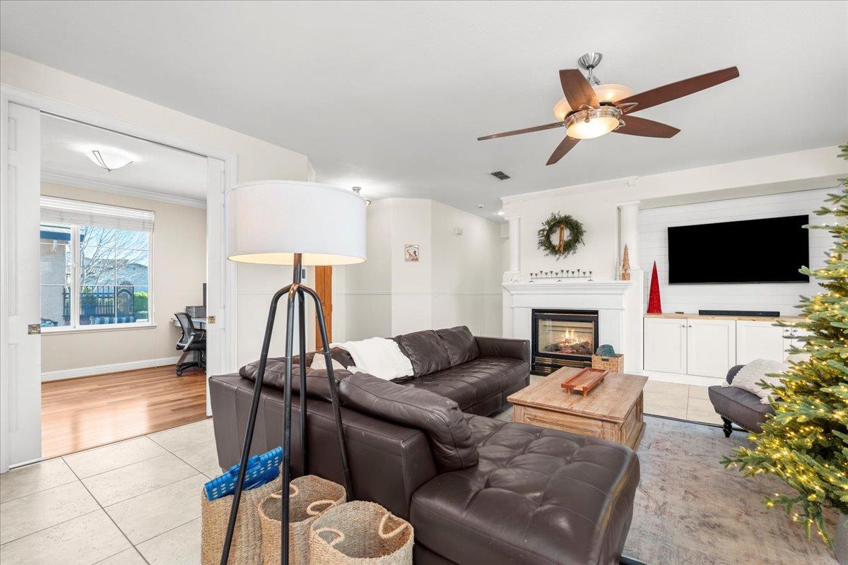 9168 Sipler Way Elk Grove, CA 95758 - Photo 8 of 35 a living room with furniture a flat screen tv and a fireplace
