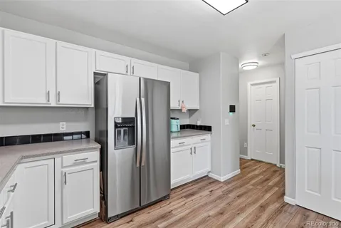 a kitchen with white cabinets and stainless steel appliances