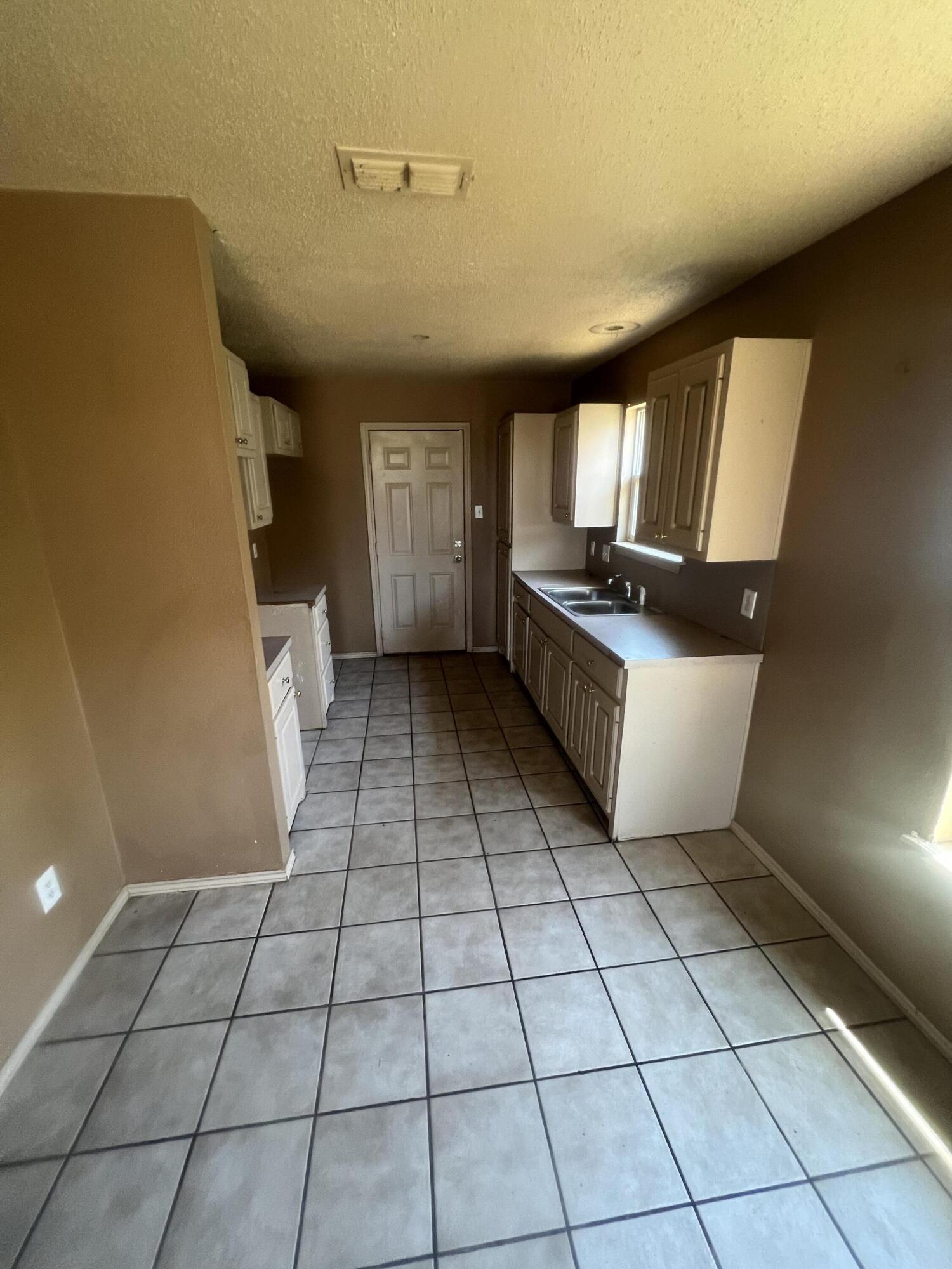 817 Ute Avenue Lubbock, TX 79403 - Photo 7 of 17 a room with a washing machine and cabinets