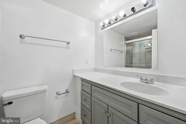 a bathroom with a sink vanity granite and toilet