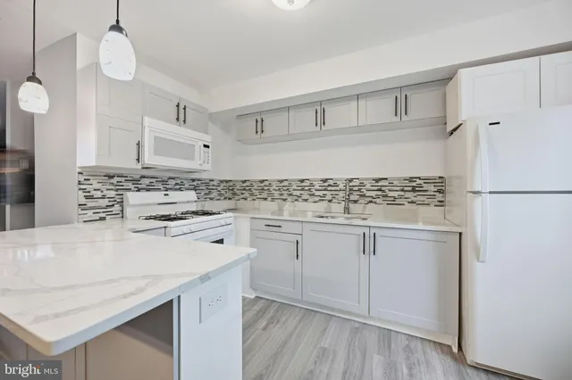 a kitchen with granite countertop white cabinets and white appliances