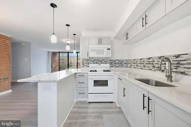 a kitchen with granite countertop white cabinets and white appliances
