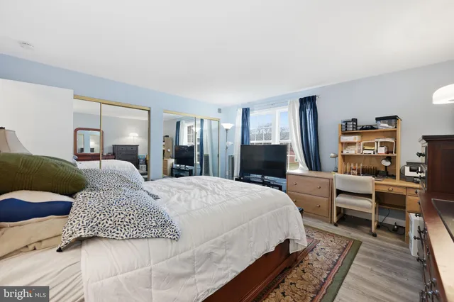 a large bedroom with a bed and wooden floor