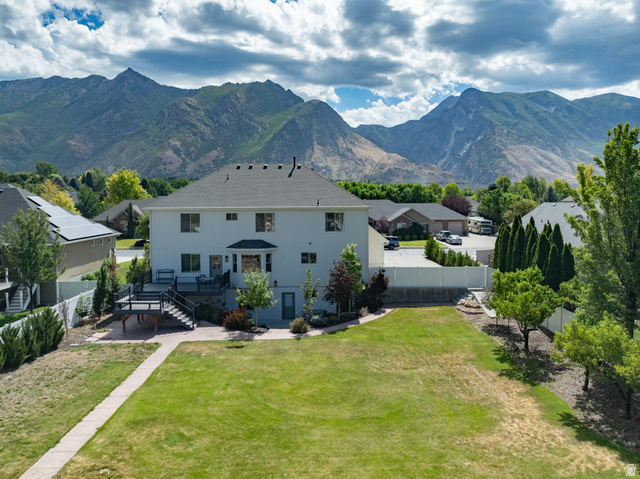 868 Braddock Lane Alpine, UT 84004 - Photo 63 of 64 Expansive backyard featuring a large green lawn, concrete paver pathway, and mature trees