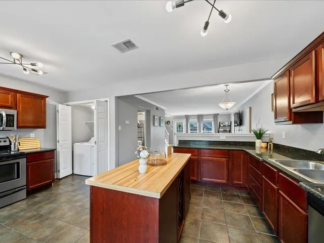 a kitchen with stainless steel appliances granite countertop a sink stove and refrigerator