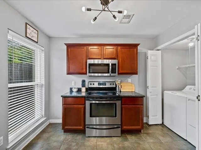 a kitchen with stainless steel appliances granite countertop a sink a stove and a refrigerator