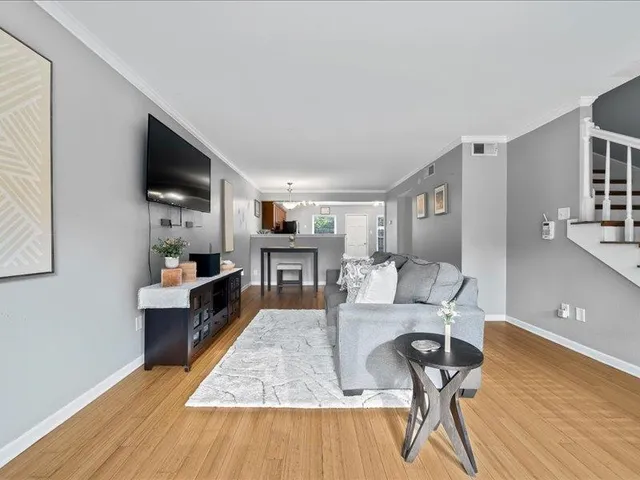 a living room with furniture a flat screen tv and kitchen view