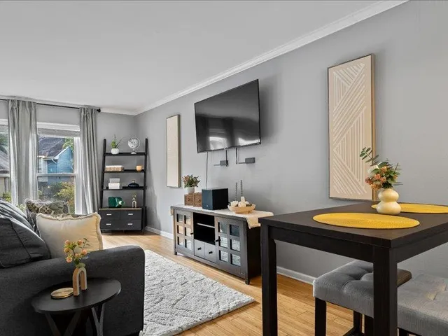 a living room with furniture a flat screen tv and a dining table