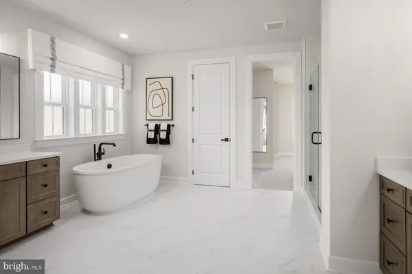 a bathroom with a bathtub sink mirror and window