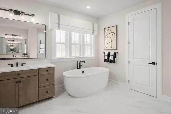 a spacious bathroom with a double vanity sink mirror and bathtub