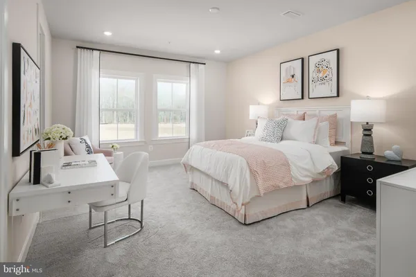 a spacious bedroom with a bed a couch and large window