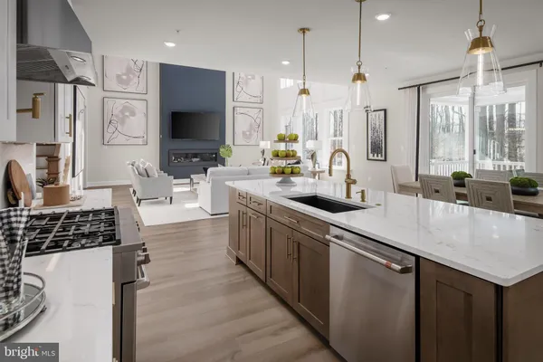 a kitchen with stainless steel appliances a sink a stove a refrigerator and cabinets