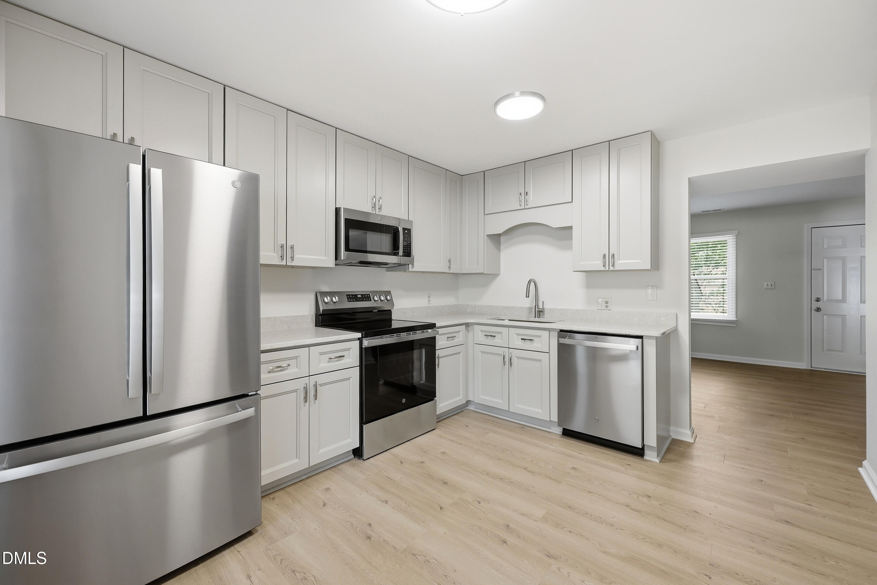 669 Bashford Road Raleigh, NC 27606 - Photo 3 of 19 a kitchen with granite countertop white cabinets and stainless steel appliances