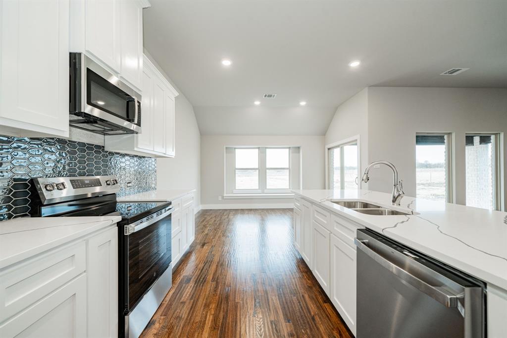 424 Deer Lane Celeste, TX 75423 - Photo 21 of 40 a kitchen with stainless steel appliances granite countertop a sink stove microwave and cabinets