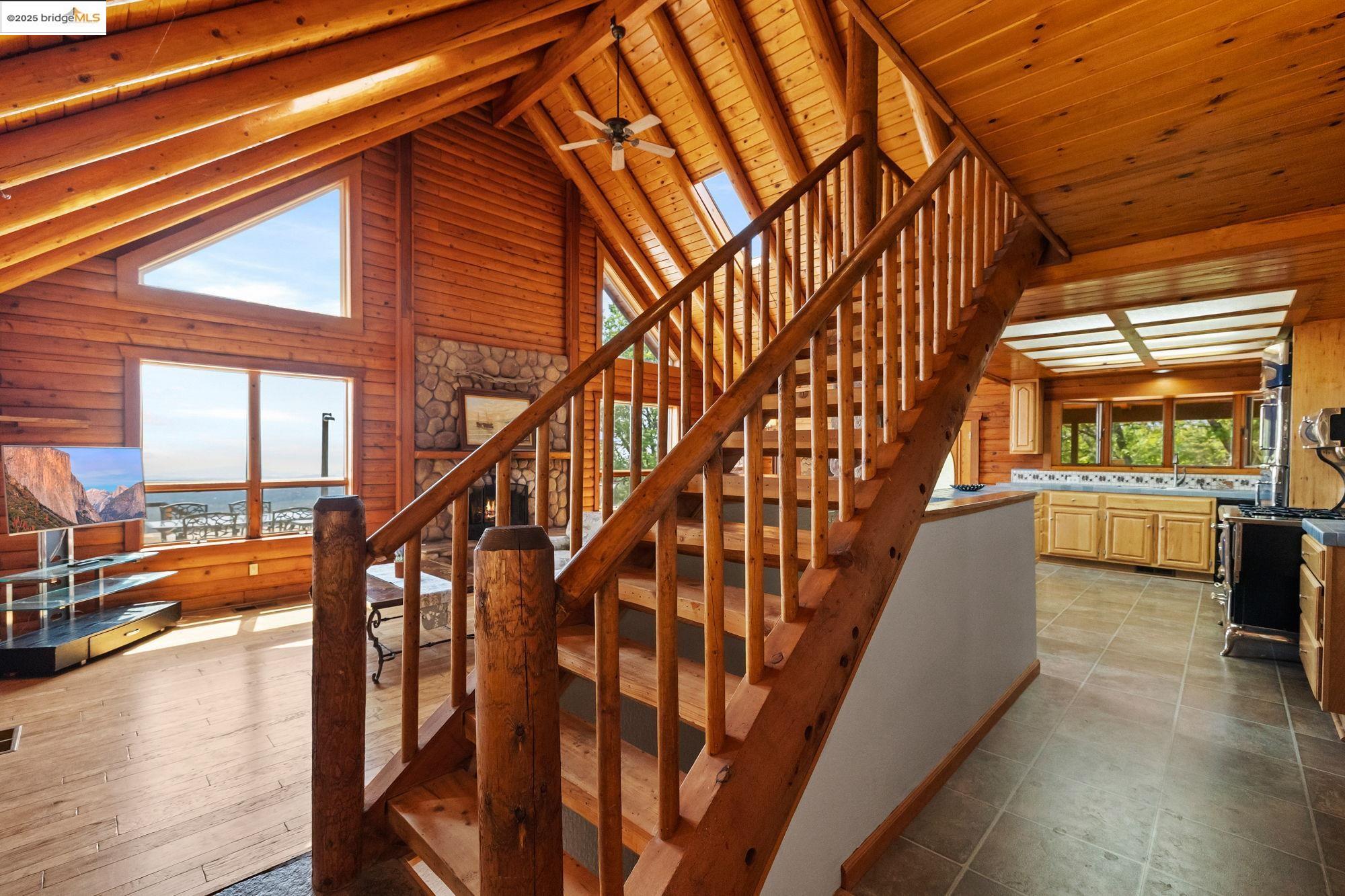 14799 Big Hill Road Sonora, CA 95370 - Photo 19 of 60 Stairs featuring high vaulted ceiling, ceiling fan, a wood ceiling with exposed beams, and wooden walls