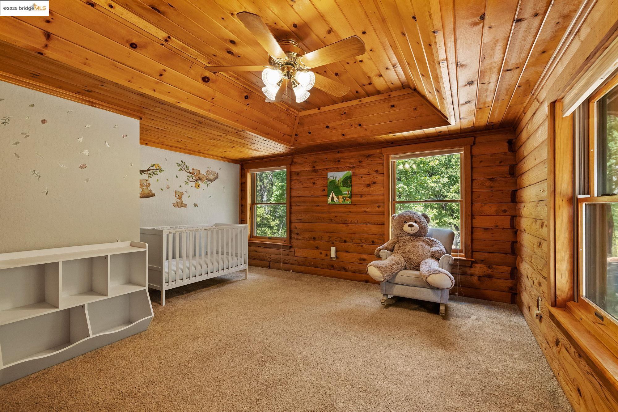 14799 Big Hill Road Sonora, CA 95370 - Photo 21 of 60 Bedroom with carpet flooring, wood ceiling, a raised ceiling, ceiling fan, and a crib