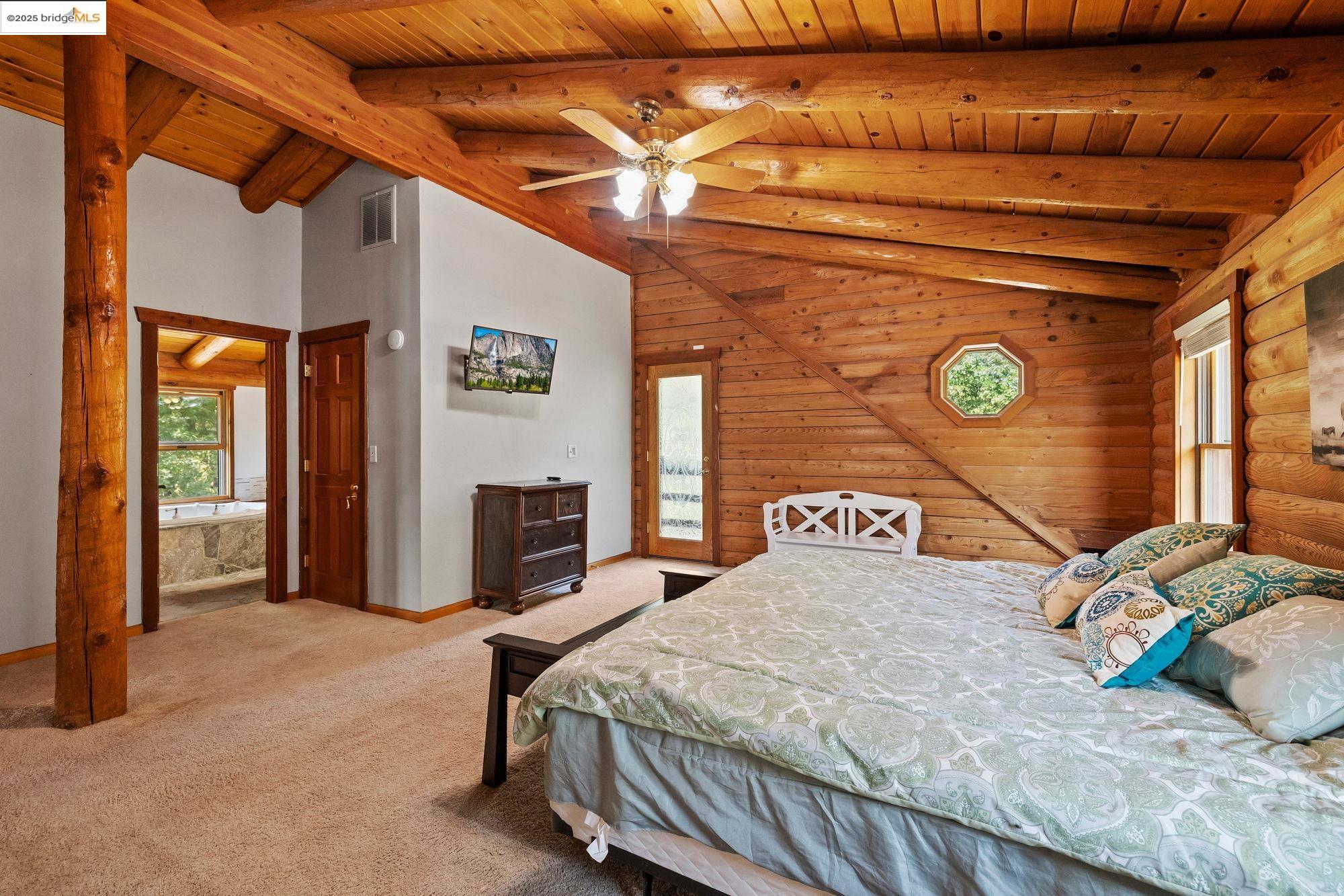 14799 Big Hill Road Sonora, CA 95370 - Photo 29 of 60 Bedroom with multiple windows, a wood ceiling with exposed beams, light carpet, high vaulted ceiling, and a ceiling fan
