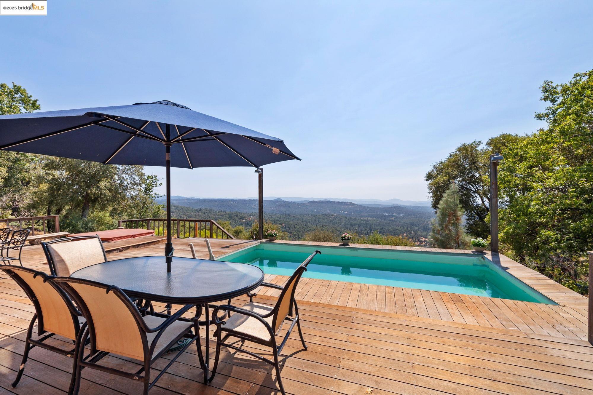 14799 Big Hill Road Sonora, CA 95370 - Photo 51 of 60 View of swimming pool featuring a deck with mountain view and outdoor dining area