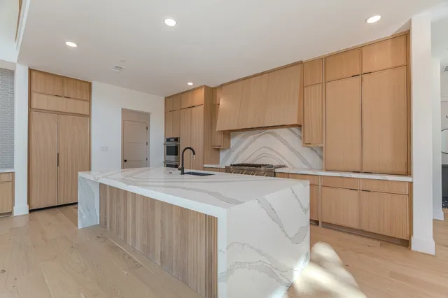 a kitchen with stainless steel appliances granite countertop a sink and a refrigerator