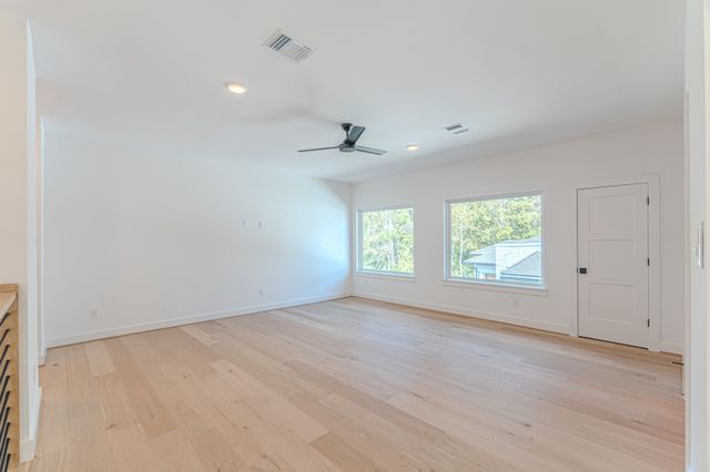 a view of a room with wooden floor and windows