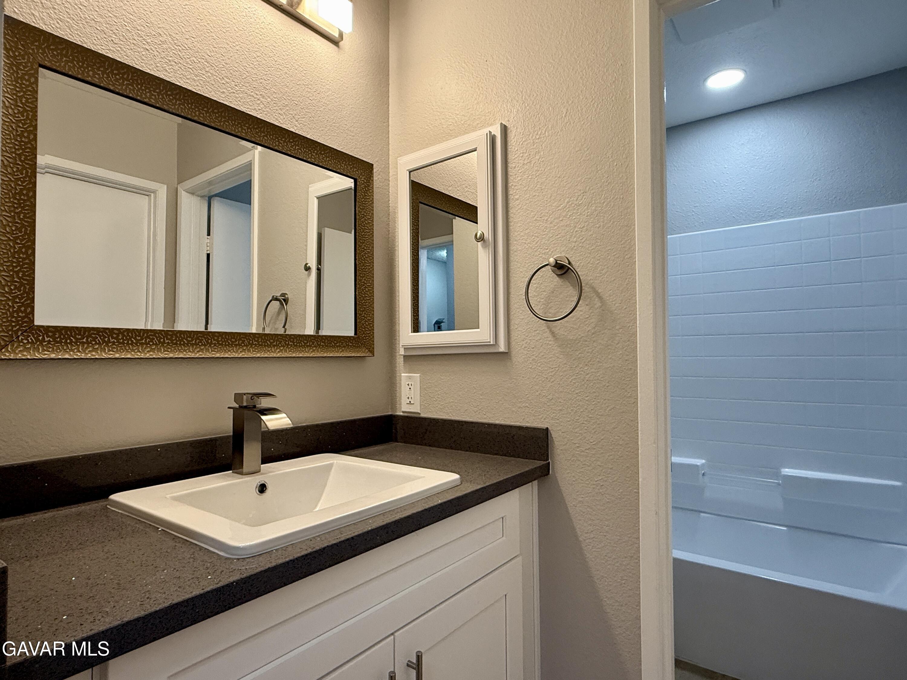 36931 Charter Court Palmdale, CA 93552 - Photo 15 of 20 a bathroom with a sink and a mirror