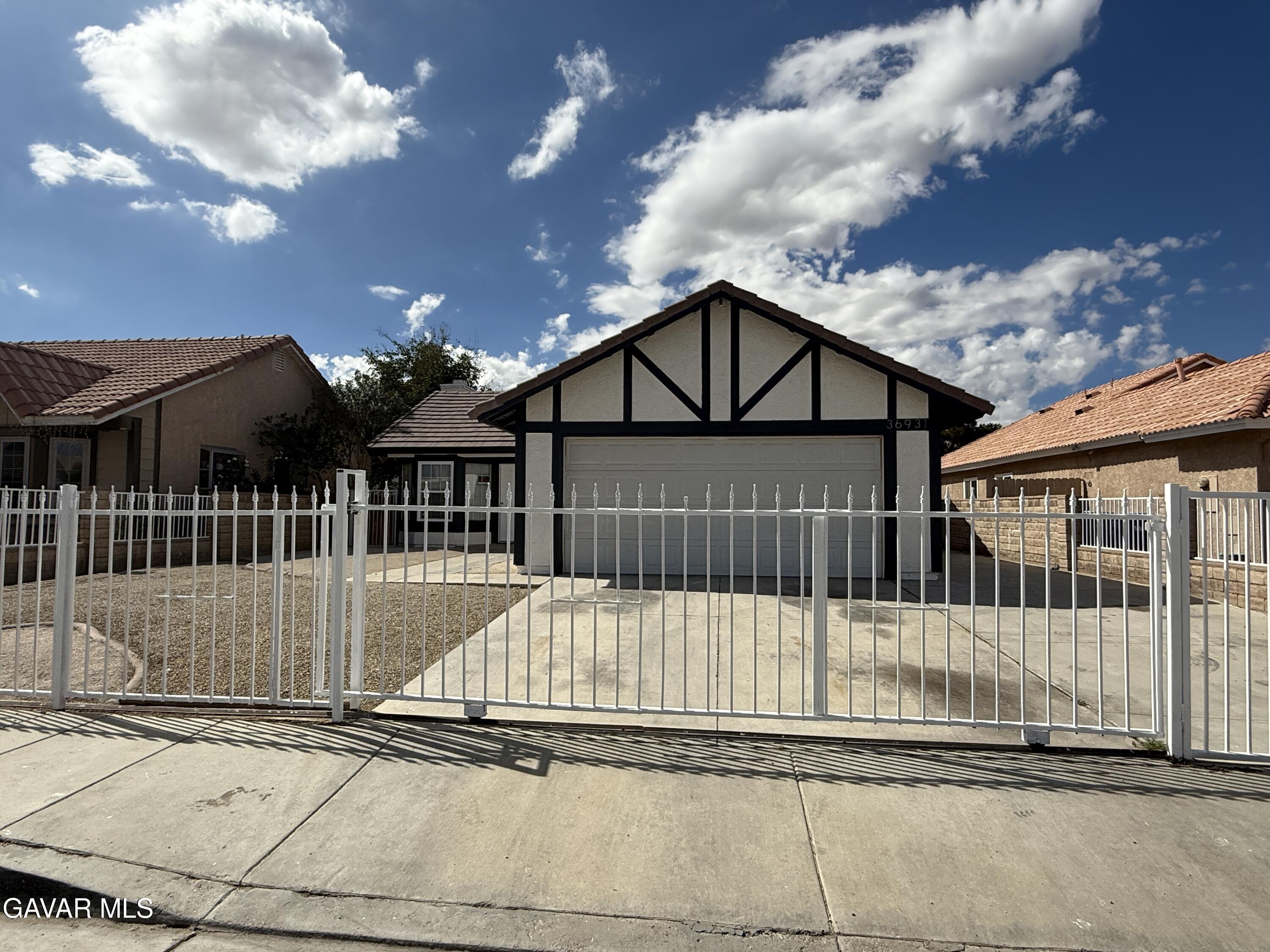 36931 Charter Court Palmdale, CA 93552 - Photo 2 of 20 a front view of a house with a iron gate
