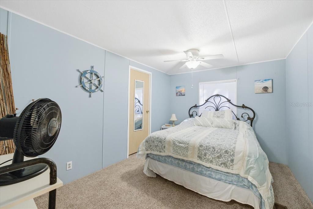6715 West Richard Drive Weeki Wachee, FL 34607 - Photo 21 of 47 a bedroom with a bed and a chandelier