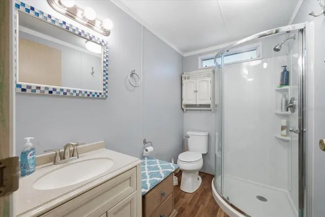 a bathroom with a granite countertop sink toilet a mirror and shower