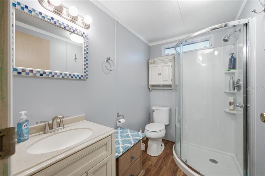 6715 West Richard Drive Weeki Wachee, FL 34607 - Photo 23 of 47 a bathroom with a granite countertop sink toilet a mirror and shower