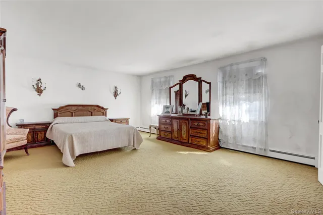 a spacious bedroom with a bed and a lamp