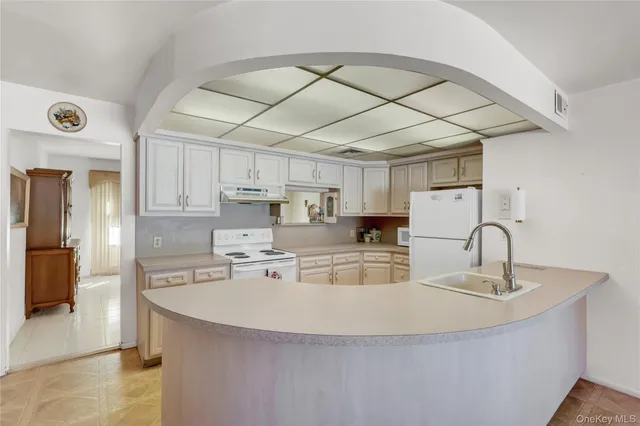 a kitchen with kitchen island a sink appliances and cabinets