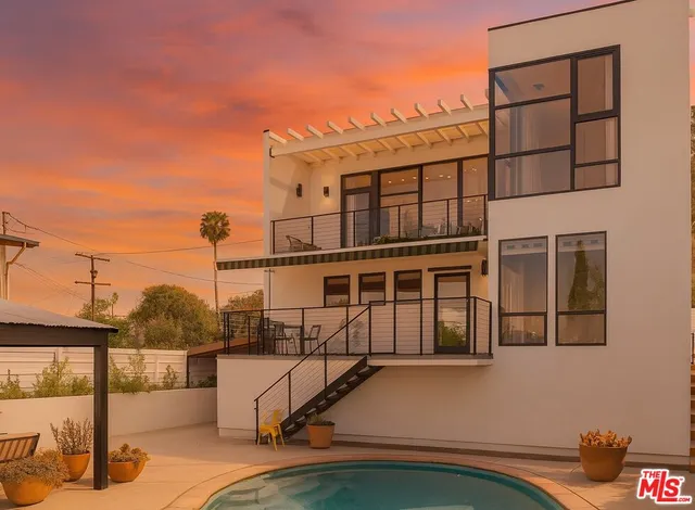 a view of a balcony with chairs and iron fence