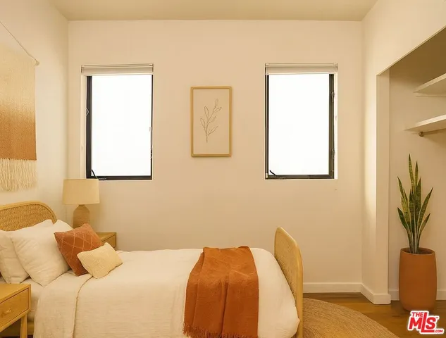 a bedroom with a bed and a potted plant