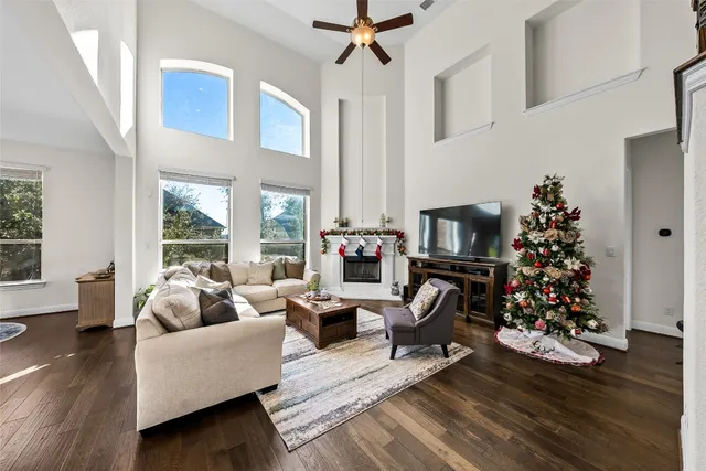 a living room with furniture large window and potted plants