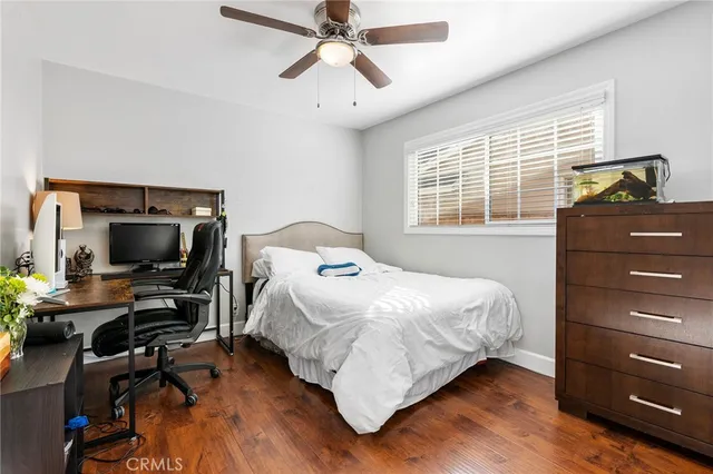 a bedroom with a bed and a flat tv screen on dresser